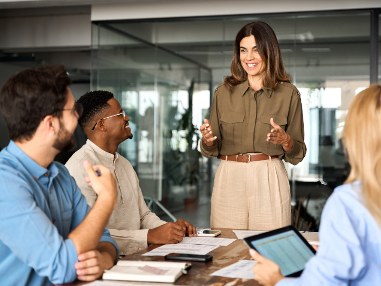 Marketing Team woman talking to a group in a conference room.